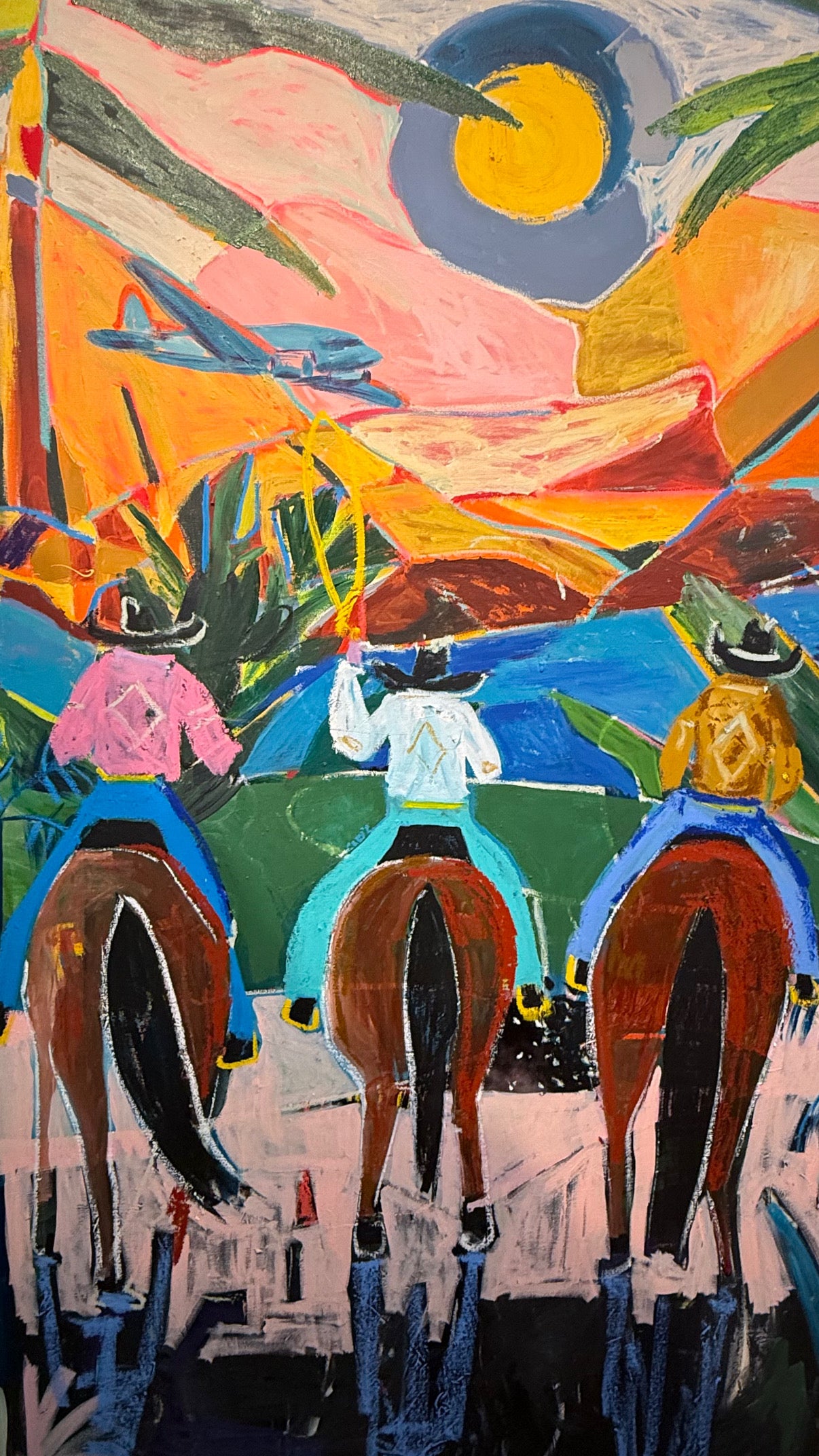 Colorful painting of cowbpys riding horses with a stylized landscape in the background.