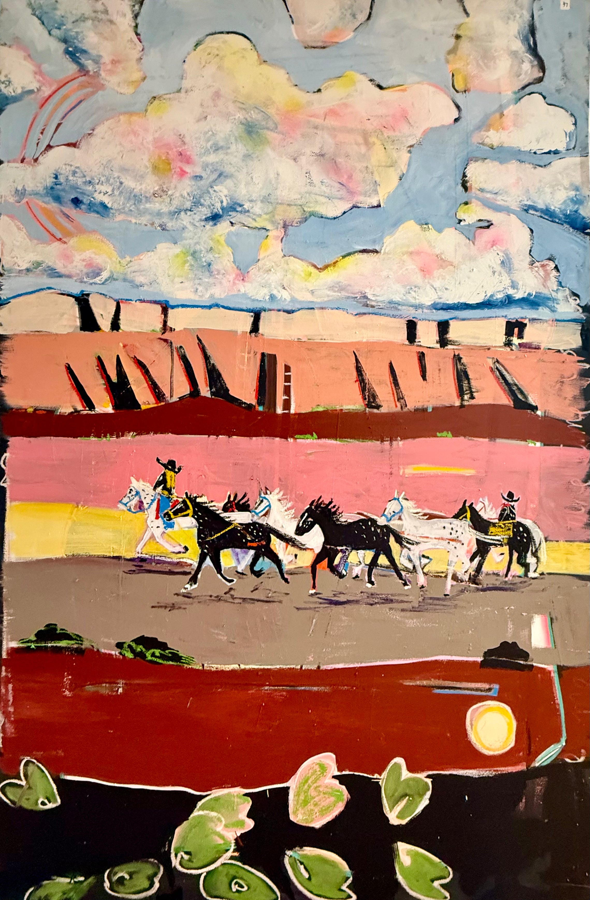 Southwestern wall art featuring horse riders traveling through a colorful desert beneath dramatic clouds.